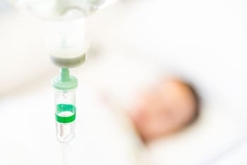 пациент лежит под капельницей